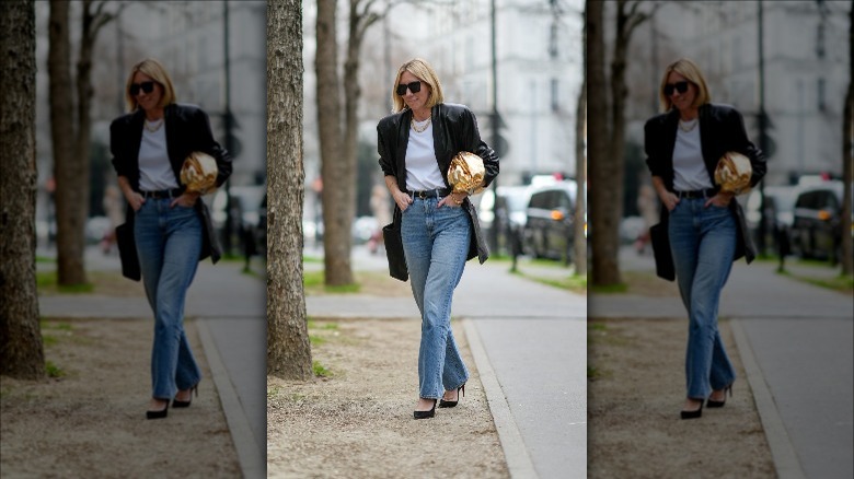woman wearing a black leather coat, blue jeans, and white t-shirt