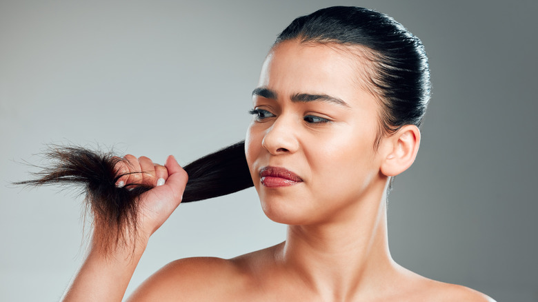 Model looking at damaged ponytail
