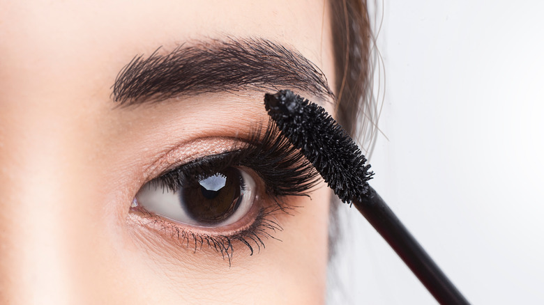 close-up of woman applying mascara