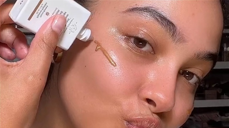 woman applying bronzing drops