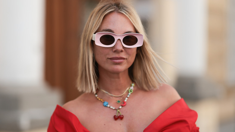Woman wearing a colorful necklace and pink sunglasses