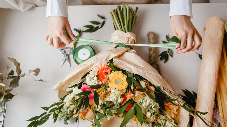 woman creating floral arrangement