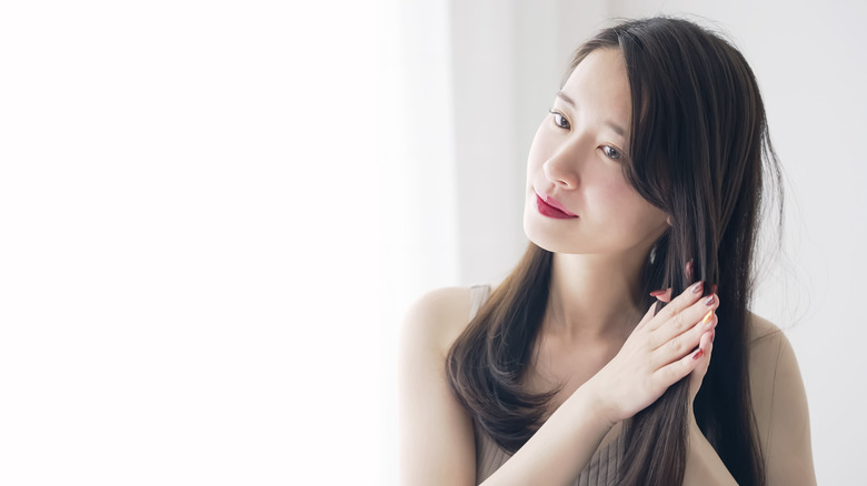 A woman applying serum to her hair