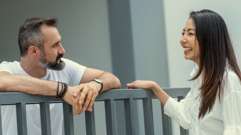 Asian woman chatting with male neighbor