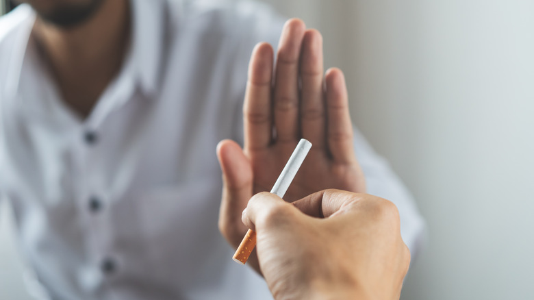 man rejecting cigarette