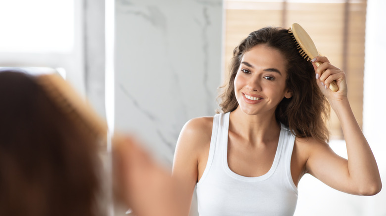 woman brushing hair back 