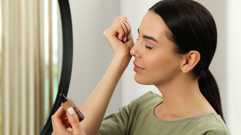 Woman smelling essential oil on wrist