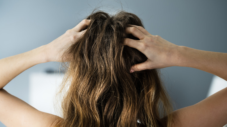 woman touching her own scalp