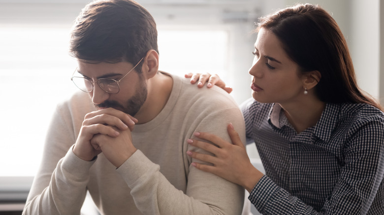 A woman holding a man's shoulder