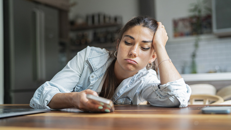 stressed woman looking at phone