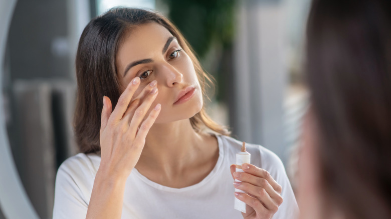 woman applying under eye concealer