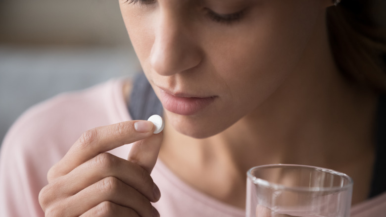 woman taking pain medicine