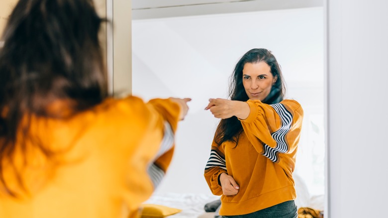 Woman pointing at herself in mirror