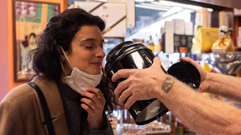 female close her eyes smelling a product at a store