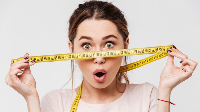 Model posing with a tape measure