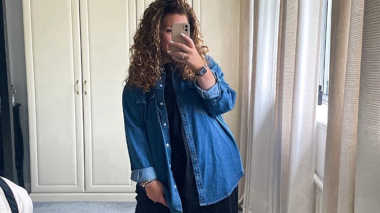 Person in denim top and black dress