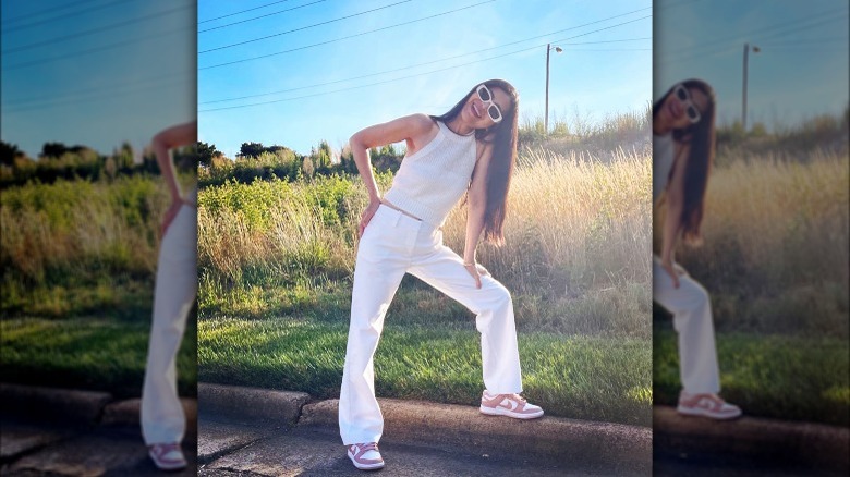Woman wearing white tank, pants