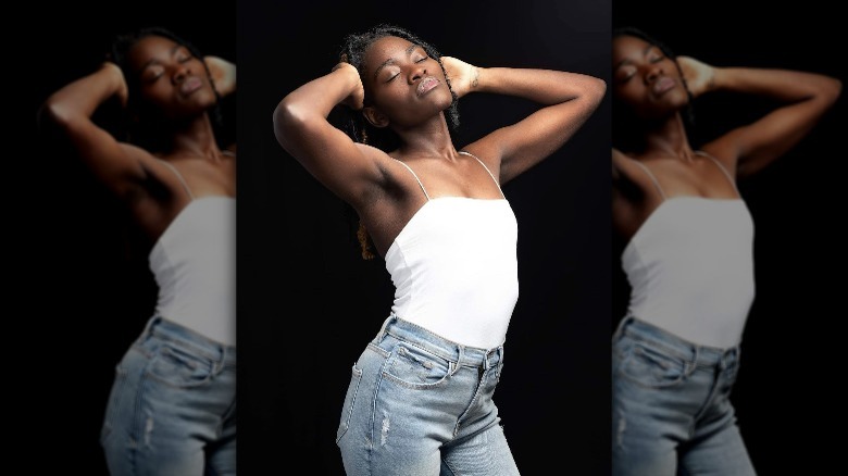 Woman wearing white tank, jeans