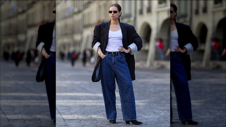 Woman wearing white tank, loose jeans