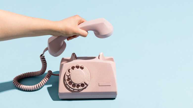 Hand hanging up retro phone