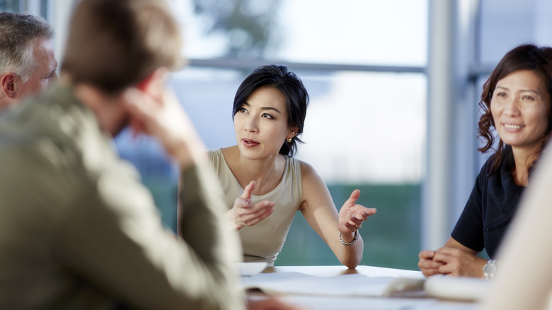 Coworkers have discussion around table