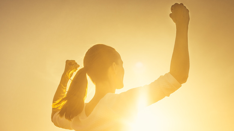 woman flexing at sunrise