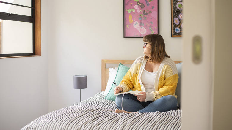woman journaling on bed