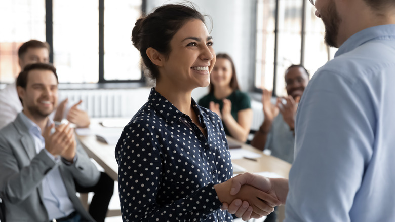 Workers congratulate Asian woman