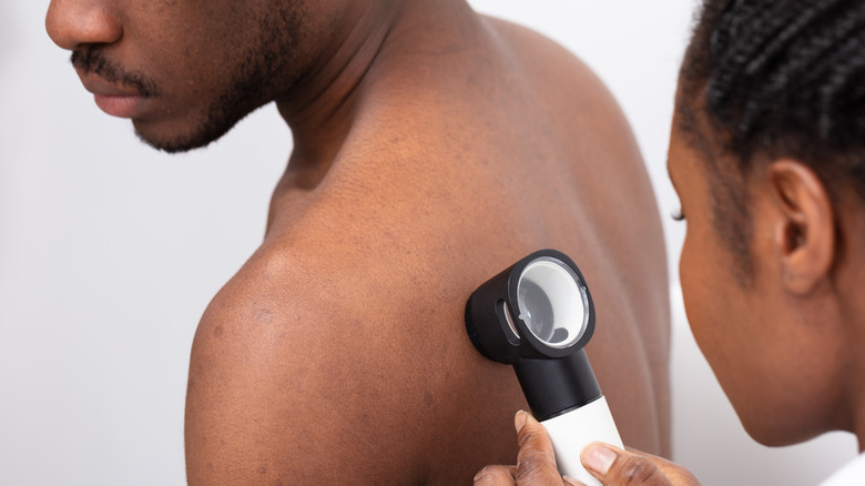 doctor checking a the back of a man