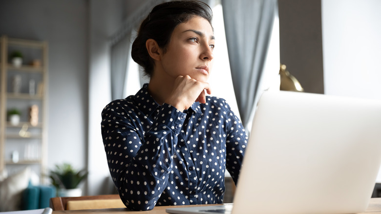Woman contemplates at desk