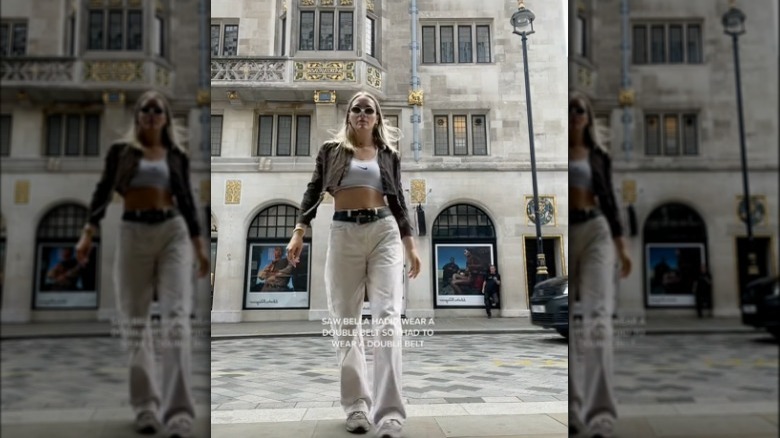 Woman wearing crop top and baggy pants with 2 belts