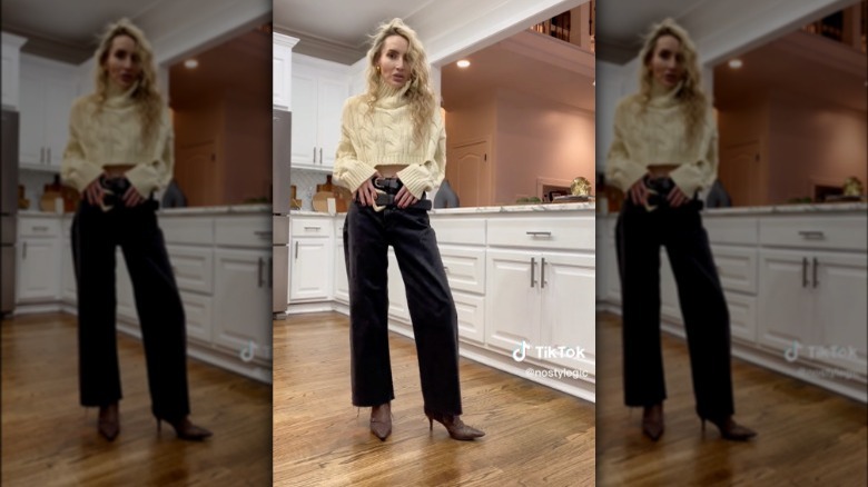 Woman wearing two belts with sweater and jeans 