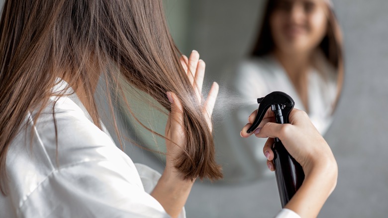 Woman spraying water on hair