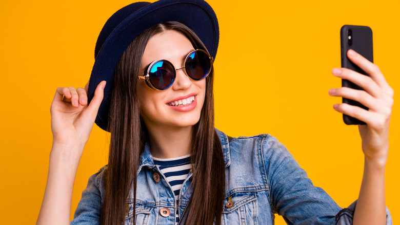 Woman wearin a hat and taking selfies