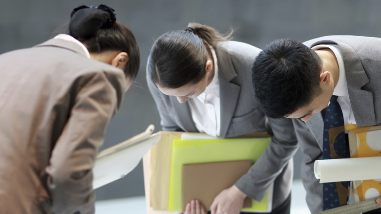 Japanese employees bowing in apology