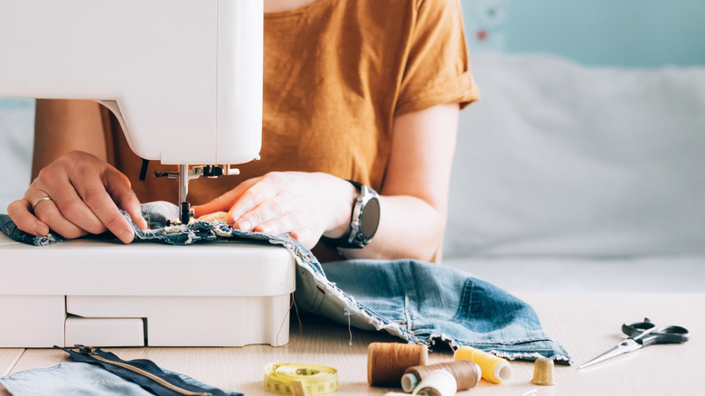 Woman sewing jeans