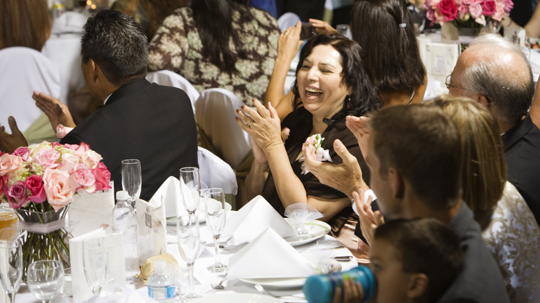 Wedding guests laughing at table