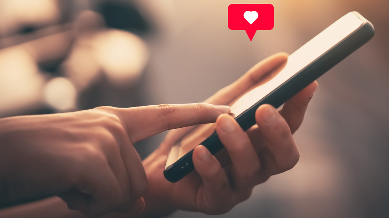 person adding heart on phone