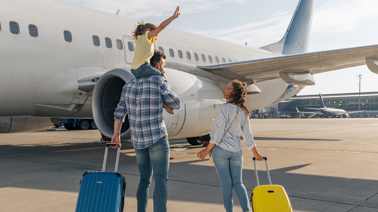 Happy family boarding airplane