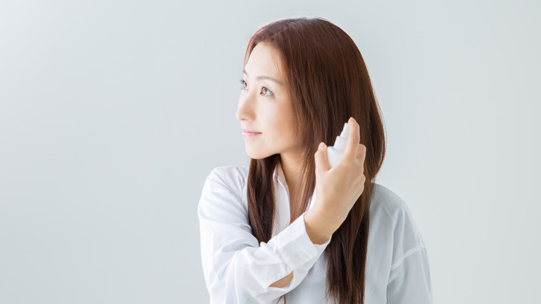 asian woman using dry shampoo