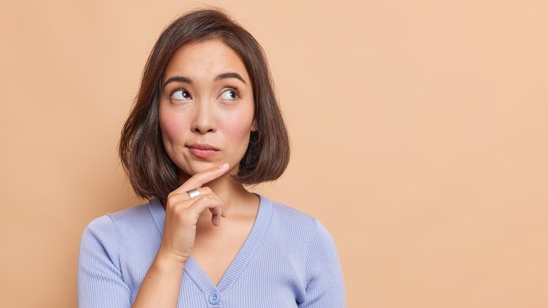 Thoughtful Asian woman considering questions