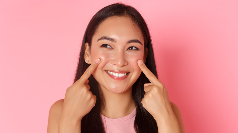 Woman pointing to her cheeks