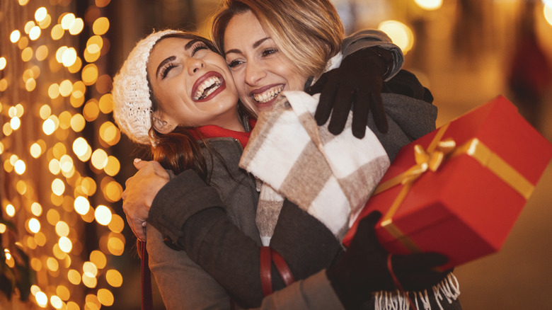 Two woman laugh and hug 
