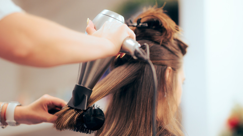 A woman getting her hair blown out at the salon