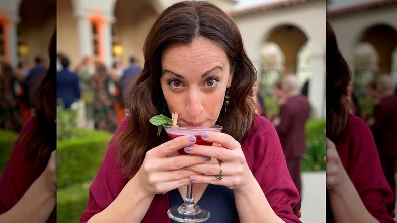 woman with drink and purple nails