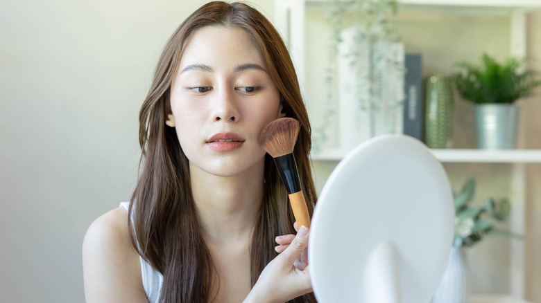Woman applying brown blush