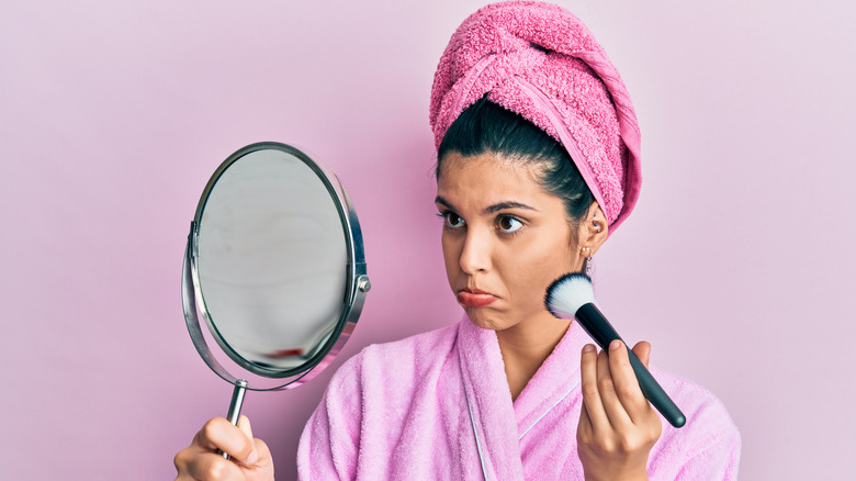 Woman upset looking in mirror