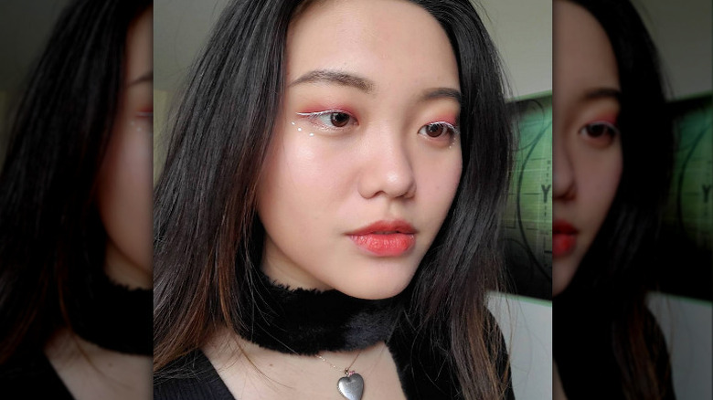 A woman with white eyeliner and pink eyeshadow