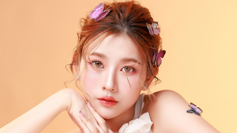 A woman wearing light eye makeup and butterfly accessories