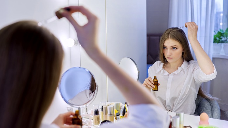 woman dropping serum in her hair